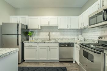 a kitchen with white cabinets and stainless steel appliances  at Avenues of Kennesaw East & West, Kennesaw, GA 30144